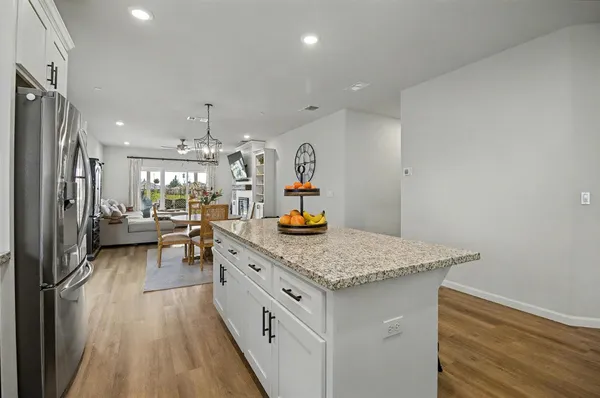 a kitchen with stainless steel appliances granite countertop a lot of counter space and wooden floors