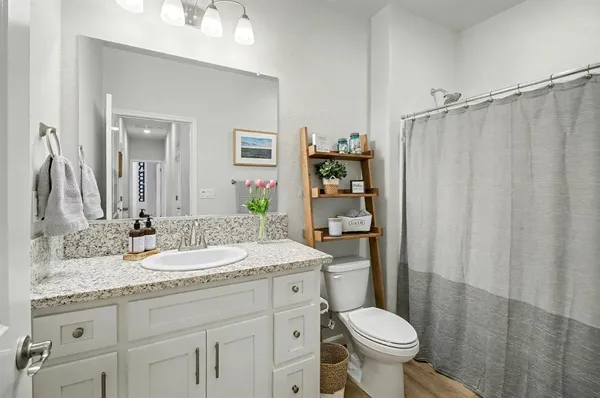 a bathroom with a granite countertop sink toilet and shower