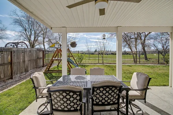 a view of a patio with table and chairs with wooden floor and fence