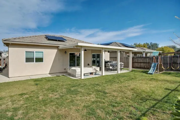 a view of a house with backyard porch and sitting area