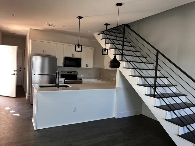 a kitchen with stainless steel appliances granite countertop a sink a stove and a refrigerator