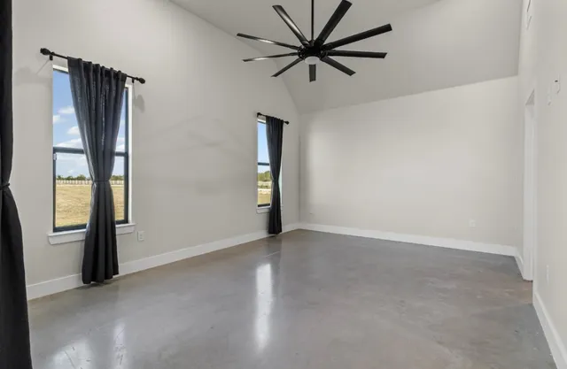 an empty room with closet and windows