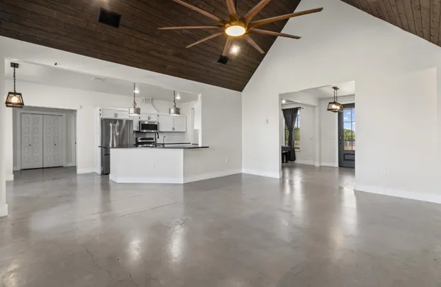 a large white kitchen with granite countertop a lot of counter space and a sink