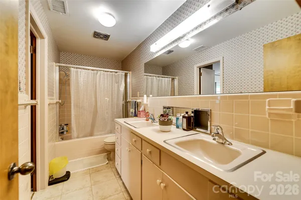 a bathroom with a sink double vanity mirror and a bathtub