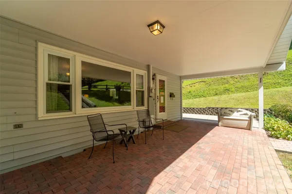a view of a porch with chairs and backyard