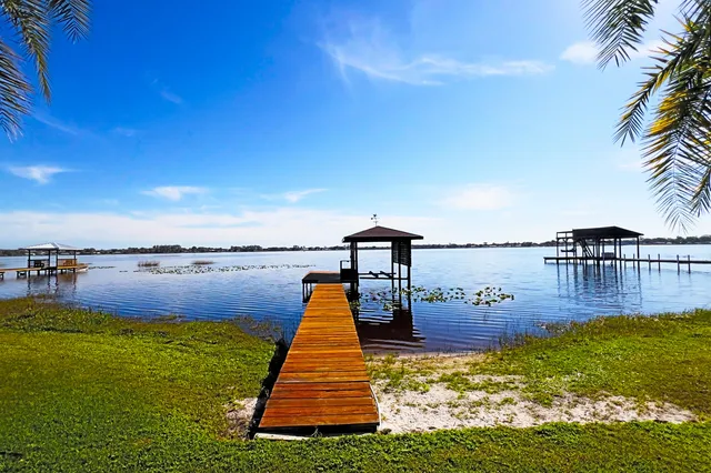 a swimming pool with yard and lake view