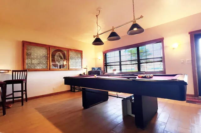 a room with pool table and windows