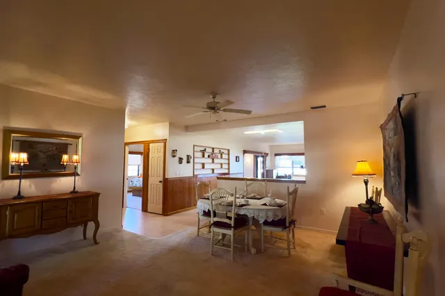 a view of a dining room with furniture a chandelier and a large window