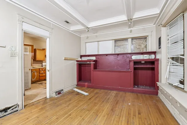 an empty room with wooden floor and entrance