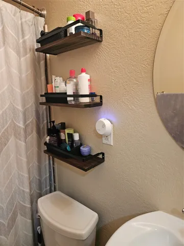 a bathroom with a toilet a sink and a mirror