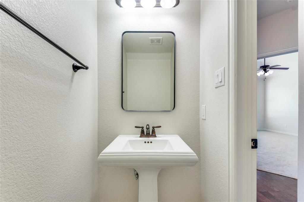 2344 Ranchview Drive Little Elm, TX 75068 - Photo 7 of 24 Pedestal sink with a bronze-finish faucet, framed mirror, and three-bulb vanity light fixture