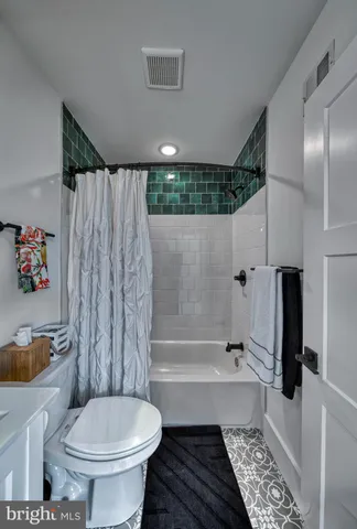 a living room with furniture and a refrigerator