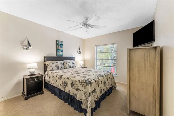 a bedroom with a bed and a flat tv screen on dresser