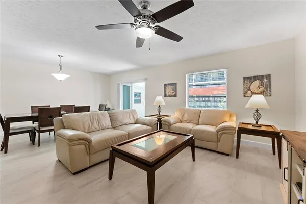a living room with furniture and a ceiling fan