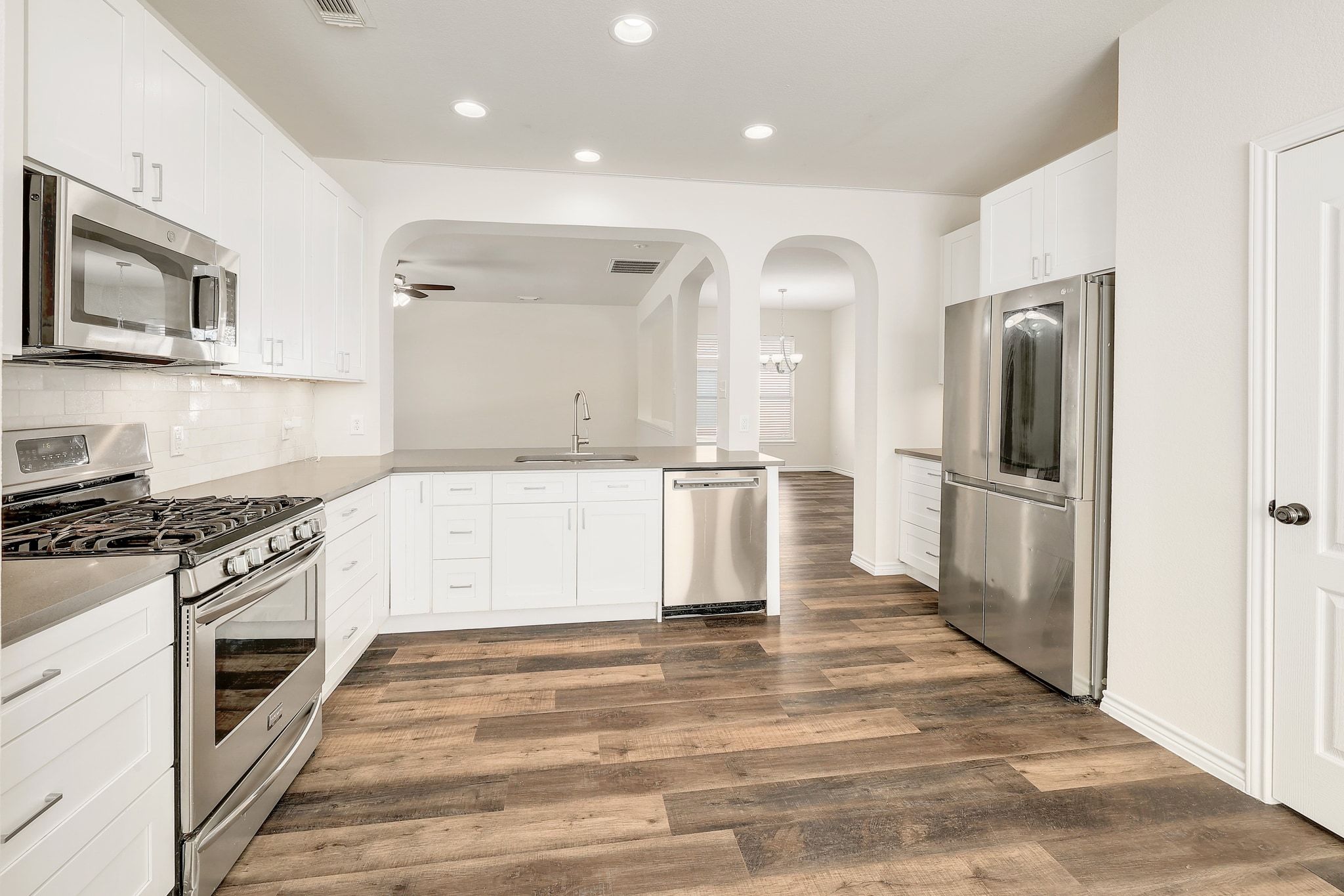 2307 Hayfield Square Pflugerville, TX 78660 - Photo 14 of 40 a large white kitchen with a stove top oven and sink