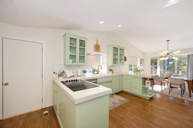 a kitchen with a refrigerator and a stove top oven