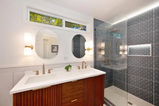 a large bedroom with a bed and a lamp on dresser