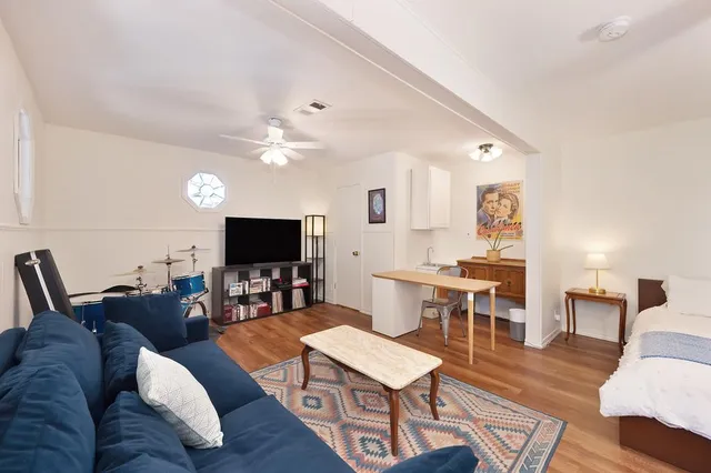 a view of a patio with table and chairs under an umbrella with a small yard