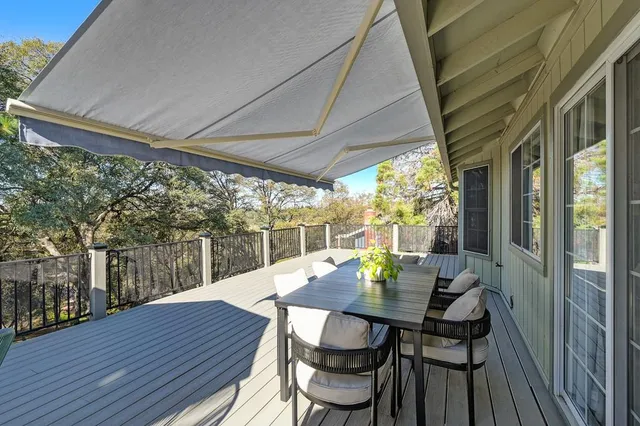 a view of a house with wooden fence next to a yard