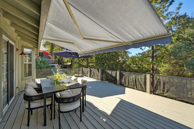 a view of a roof deck with table and chairs under an umbrella