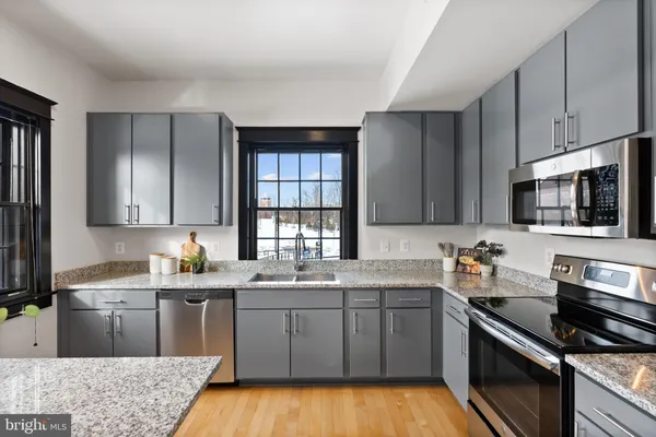 a kitchen with a sink stove top oven and microwave