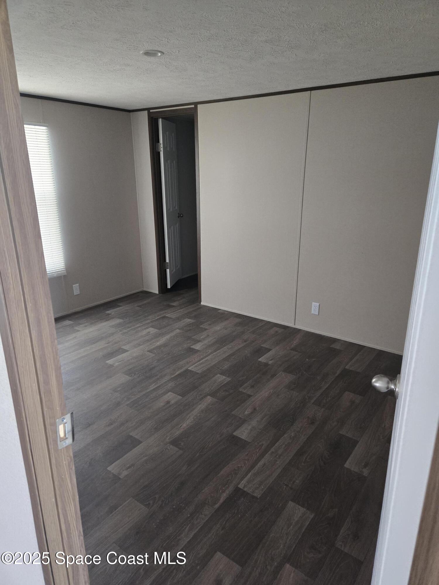 2534 Amberly Road Northeast Palm Bay, FL 32905 - Photo 3 of 6 an empty room with a wooden door