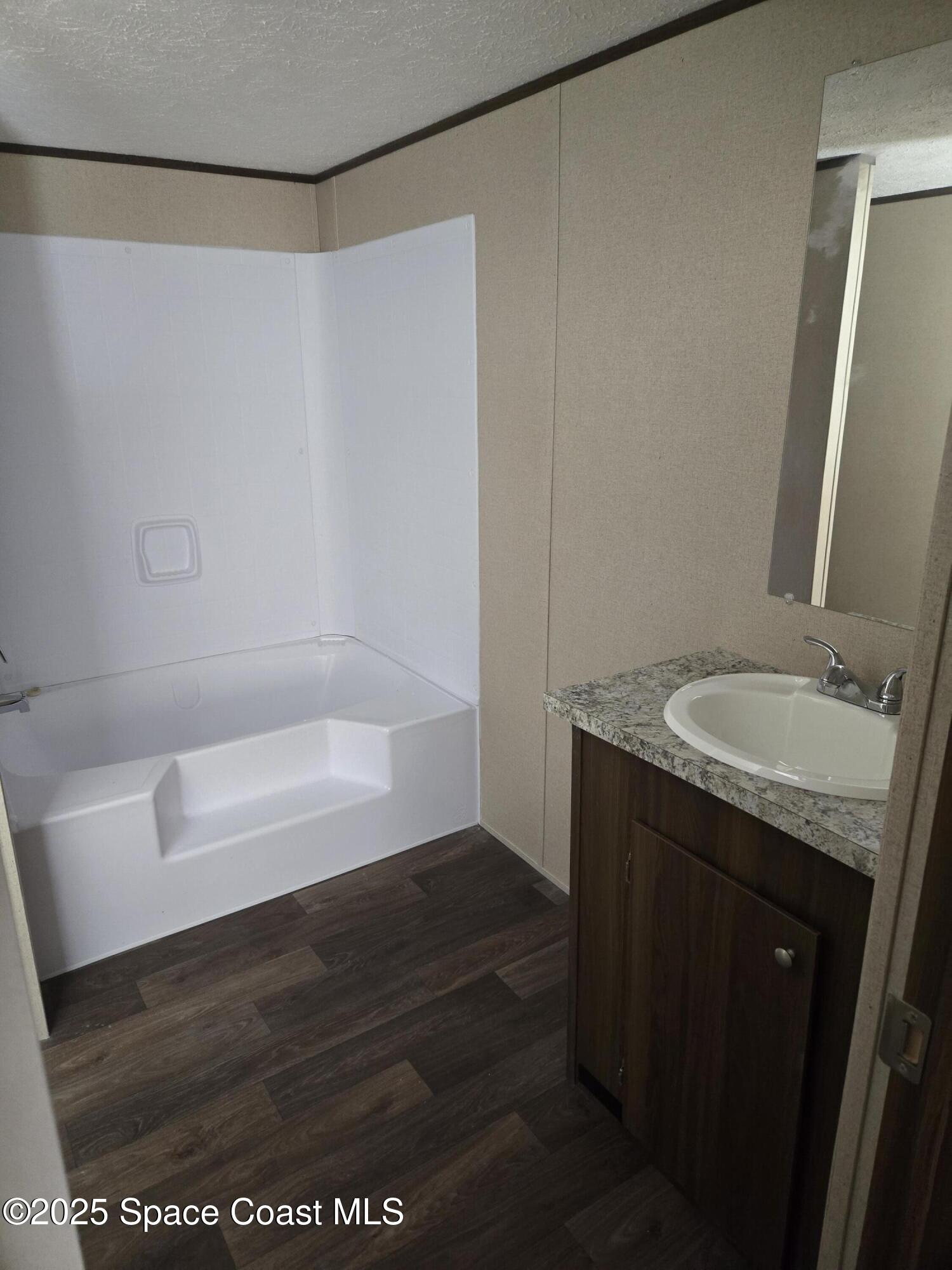 2534 Amberly Road Northeast Palm Bay, FL 32905 - Photo 5 of 6 a bathroom with a granite countertop sink and a mirror