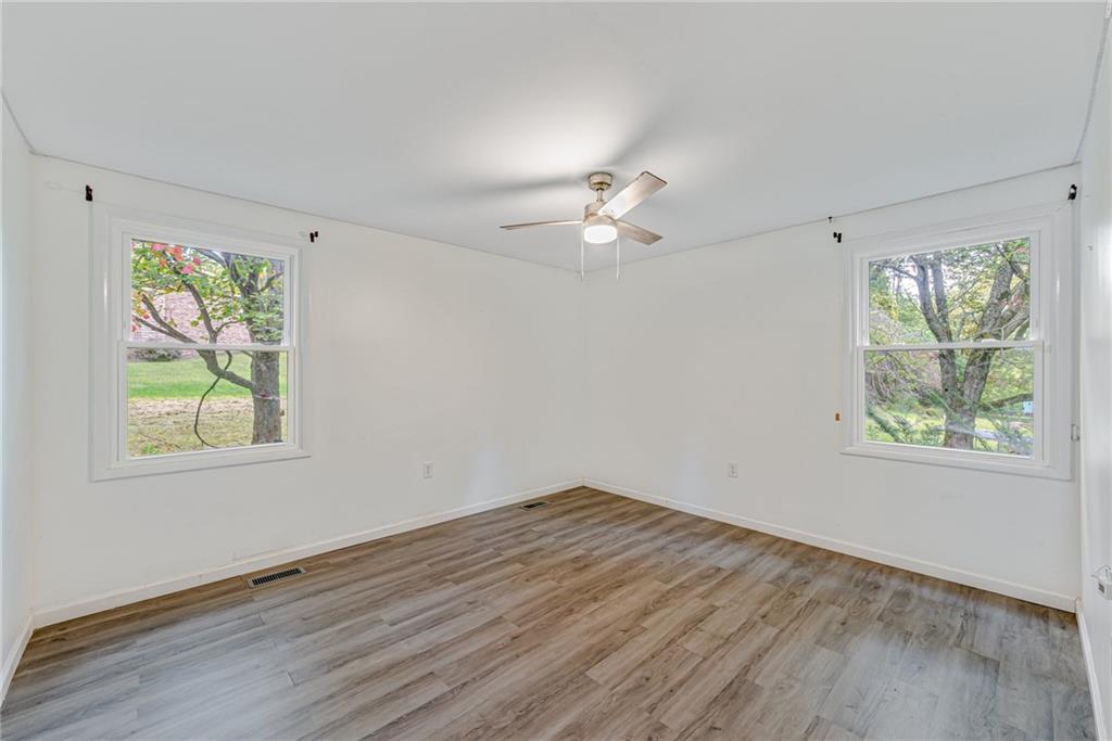 486 Engle Road Industry, PA 15052 - Photo 17 of 38 a view of an empty room with a window and wooden floor