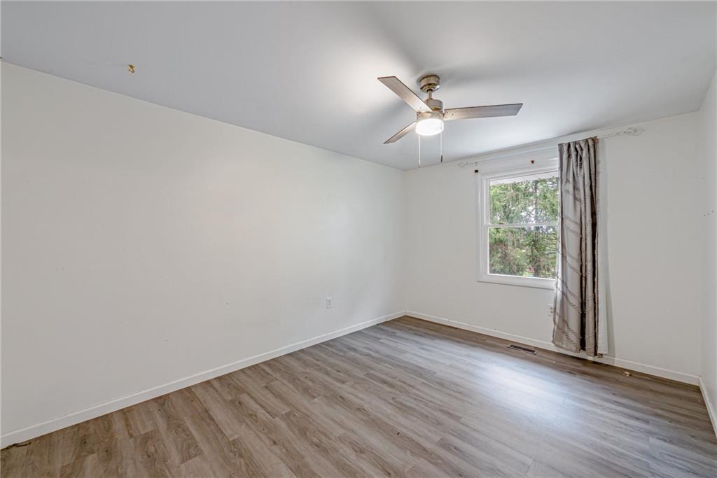 486 Engle Road Industry, PA 15052 - Photo 19 of 38 an empty room with wooden floor ceiling fan and windows