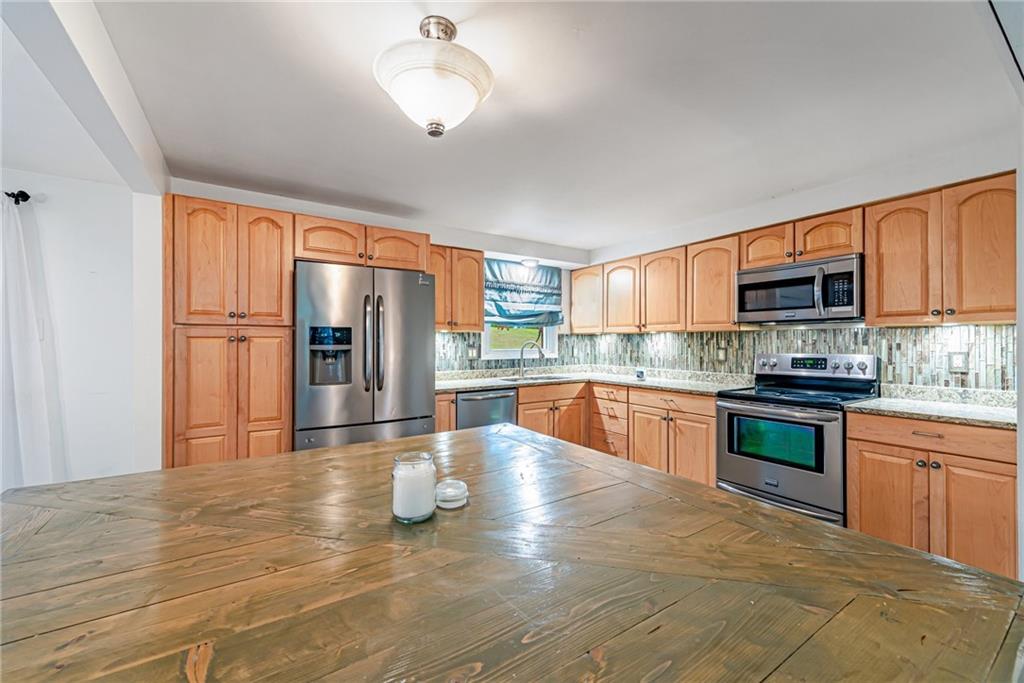 486 Engle Road Industry, PA 15052 - Photo 10 of 38 a large kitchen with stainless steel appliances granite countertop a refrigerator stove top oven and sink