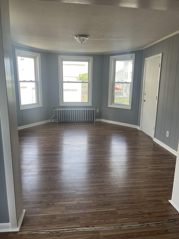 246 Eagle Street, Unit 1W Fall River, MA 02721 - Photo 3 of 8 an empty room with wooden floor and windows