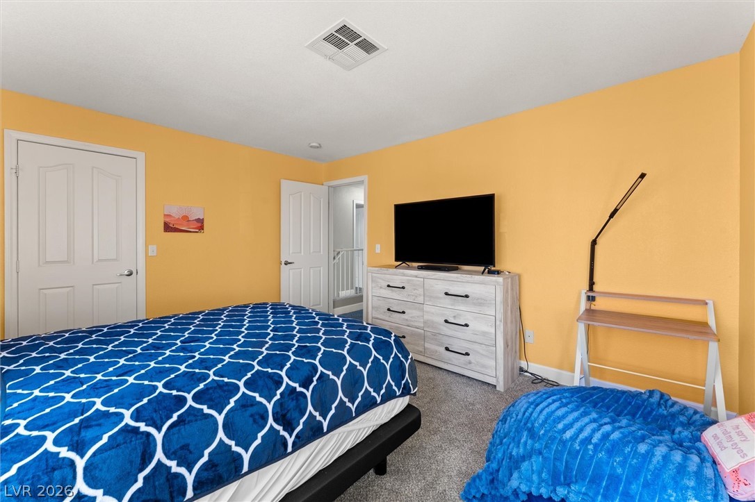 503 Rafkin Place Henderson, NV 89052 - Photo 14 of 18 A cheerful bedroom features carpeted flooring and a bright, airy ambiance.