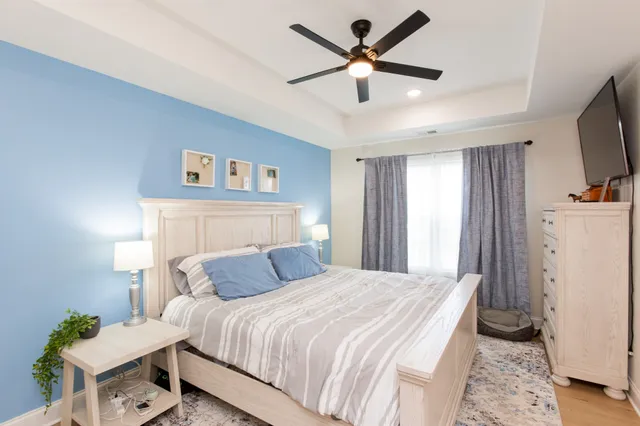 a bedroom with a large bed a flat tv screen and a dresser