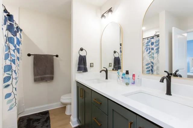 a bathroom with a double vanity sink toilet and mirror