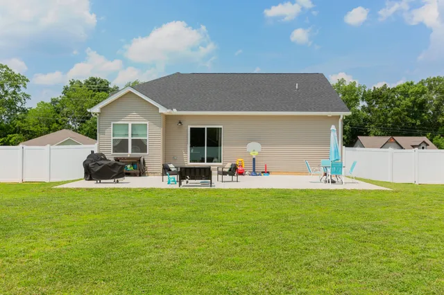 a view of a house with backyard and sitting area