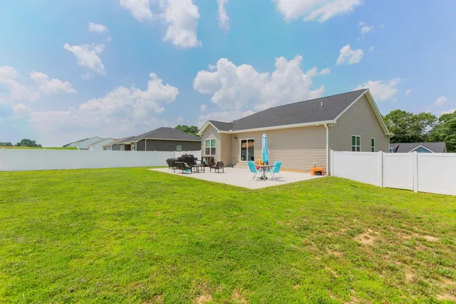 a view of a patio with table and chairs under an umbrella
