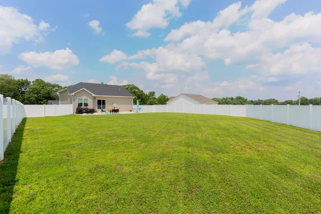 a house view with swimming pool and trees in the background