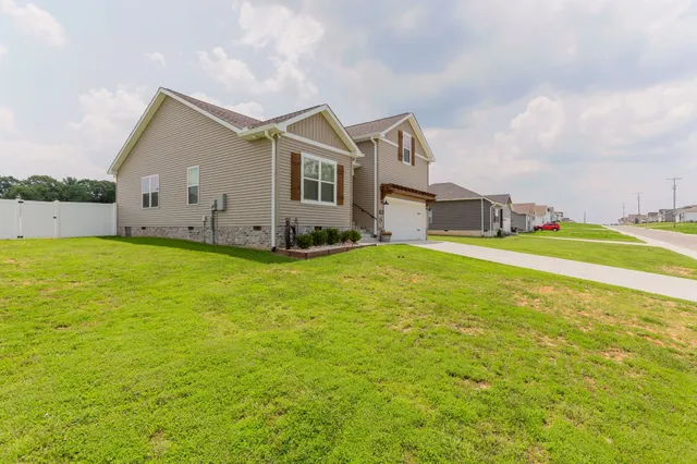 a view of a house with a big yard and large trees
