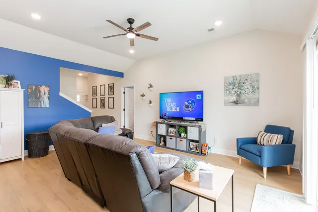 a living room with furniture a red couch and a flat screen tv