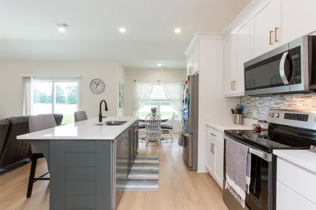 a kitchen with stainless steel appliances kitchen island granite countertop a sink and cabinets