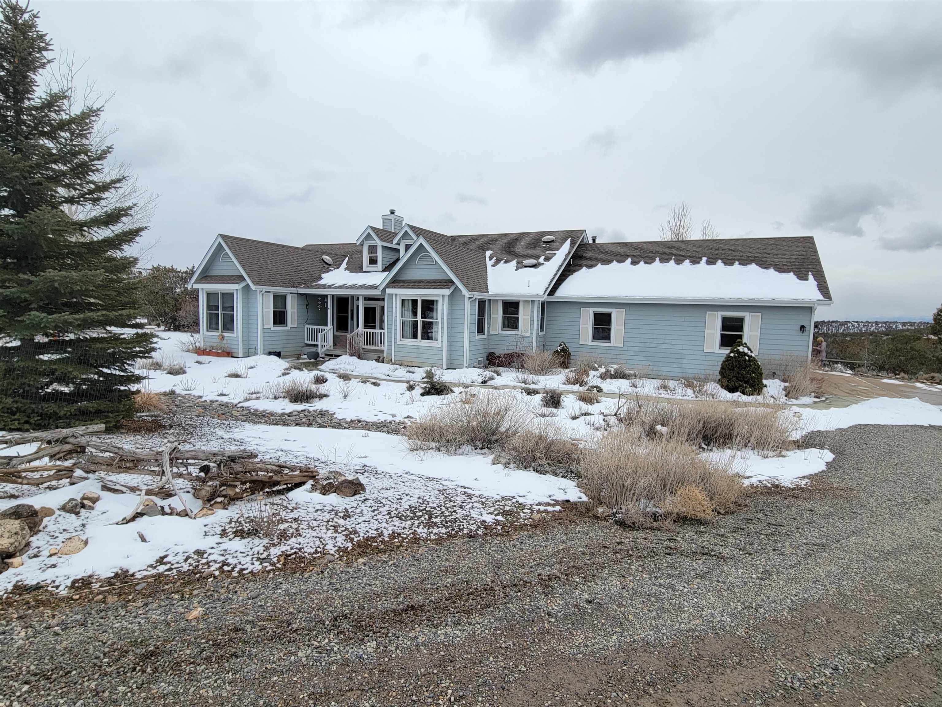 a front view of a house with a yard covered with snow