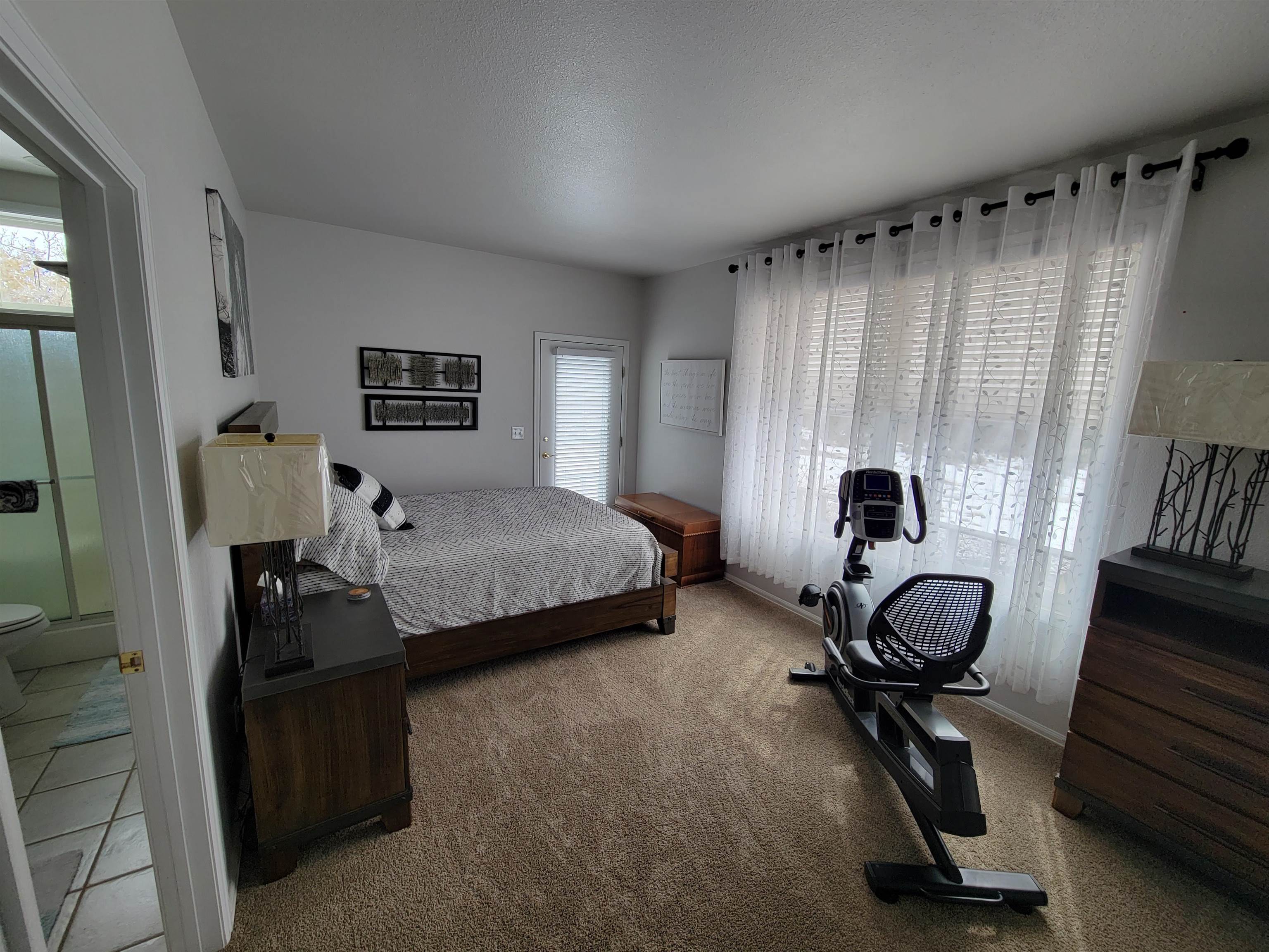 15753 Heavens View Road Cedaredge, CO 81413 - Photo 18 of 33 a bedroom with a bed and a chandelier