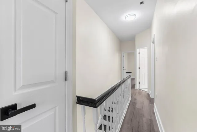 a view of a hallway with wooden floor and entryway