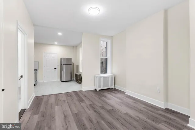 a view of a big room with wooden floor and windows