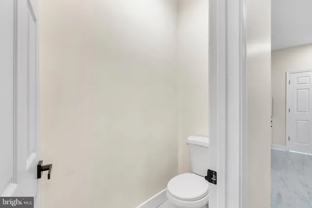 a white toilet sitting next to a white cabinet