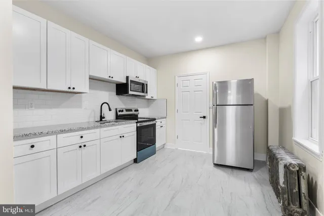 a kitchen with stainless steel appliances a refrigerator sink and microwave