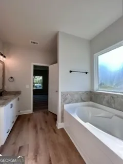 a spacious bathroom with a bathtub and a sink