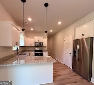 a kitchen with stainless steel appliances kitchen island granite countertop a refrigerator a sink and a stove