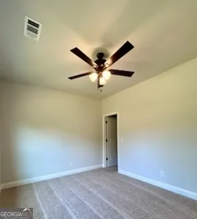 an empty room with a ceiling fan and a window