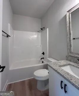 a bathroom with a granite countertop sink a toilet and shower